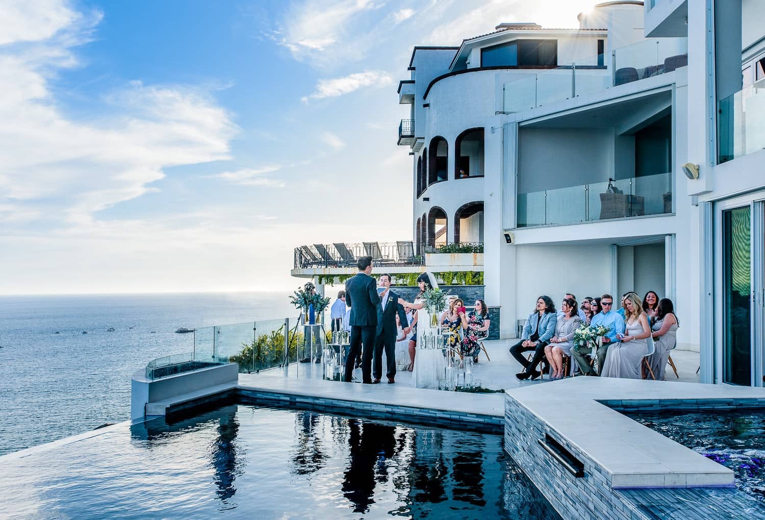 Bride and groom at the altar during a Villa Lands End cliffside Cabo wedding, infinity pool and Pacific behind
