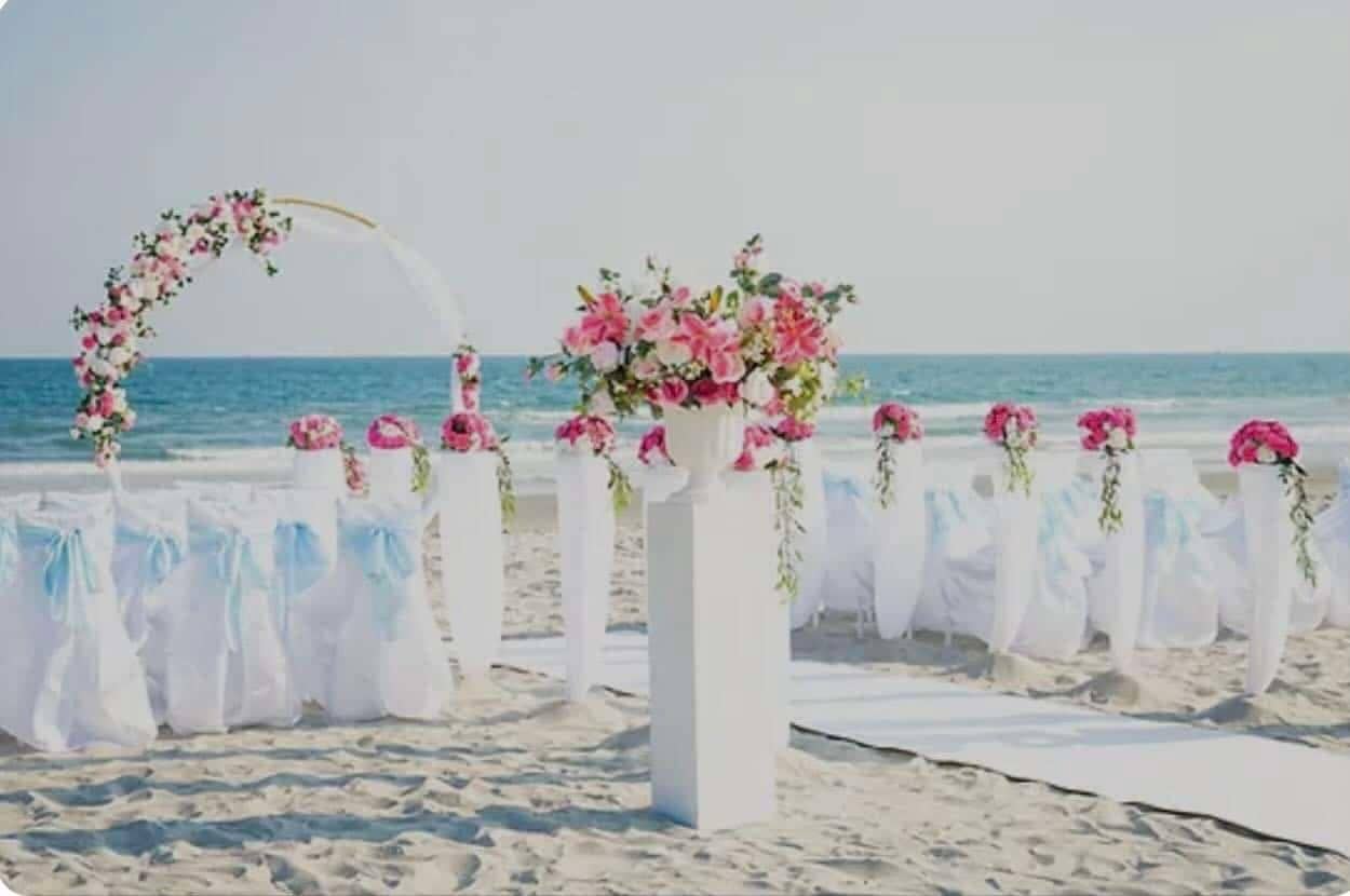 Casa Mareva cabo wedding ceremony setup with circular floral arch, white aisle, and ocean behind